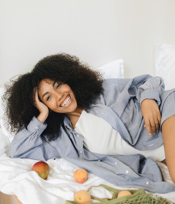 Smiling woman in a comfortable pose, radiating calmness and well-being.